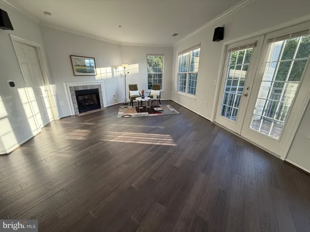 a view of a livingroom with furniture wooden floor and a window