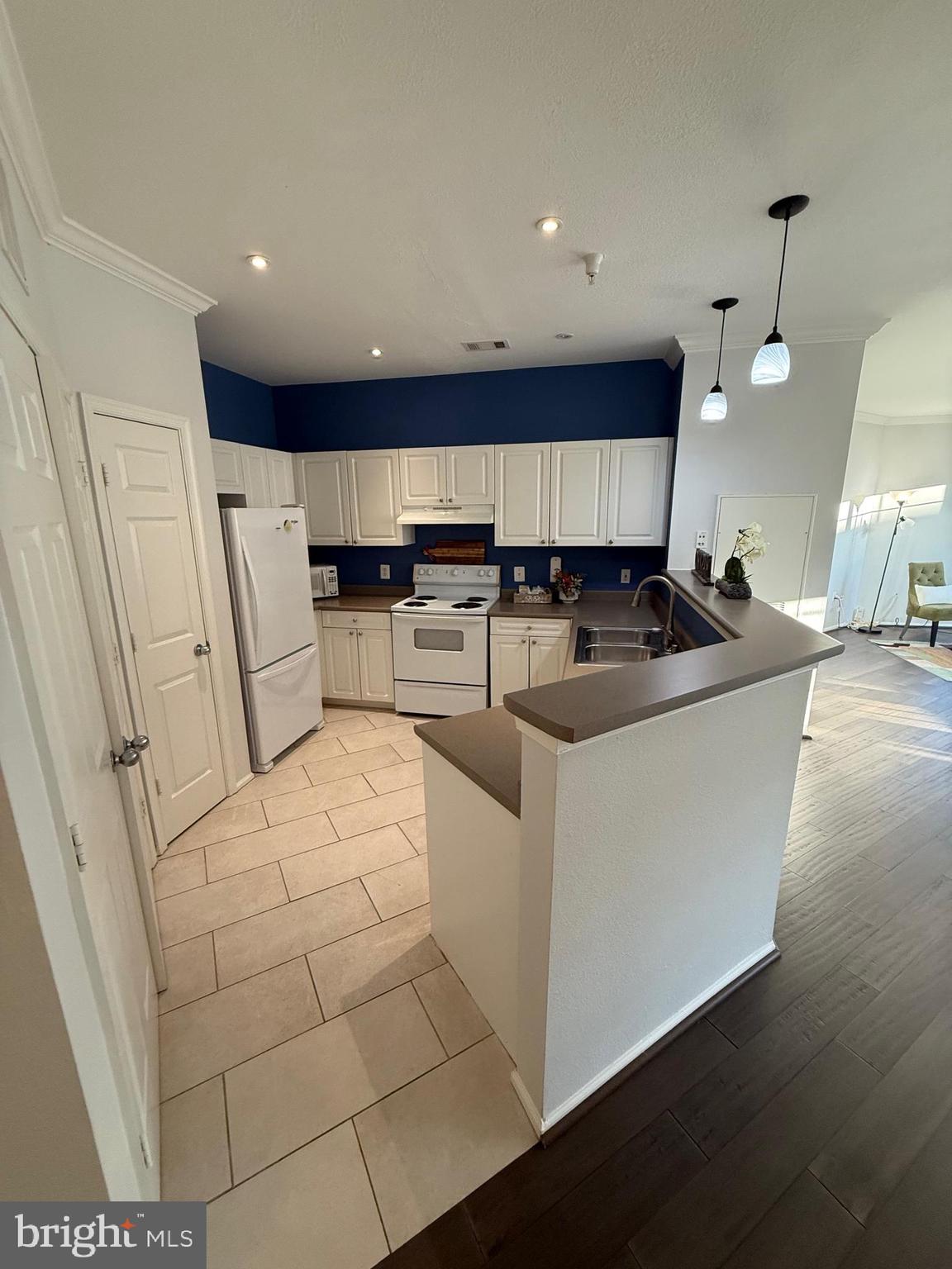 3009 Nicosh Circle, Unit 4302 Falls Church, VA 22042 - Photo 10 of 32 a kitchen with stainless steel appliances a refrigerator a sink a stove a microwave and wooden cabinets