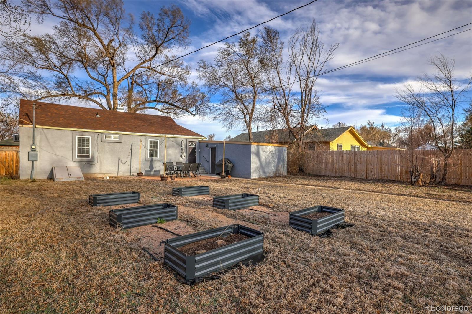 2411 Wyoming Avenue Pueblo, CO 81004 - Photo 21 of 25 a view of backyard with wooden fence and large trees