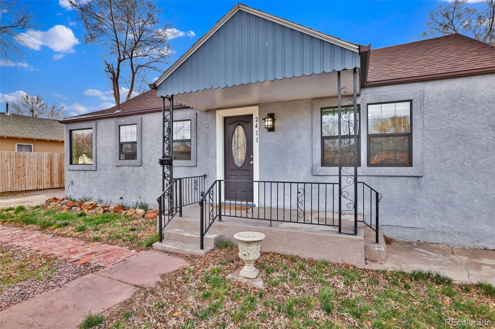 2411 Wyoming Avenue Pueblo, CO 81004 - Photo 4 of 25 a front view of a house with a garden
