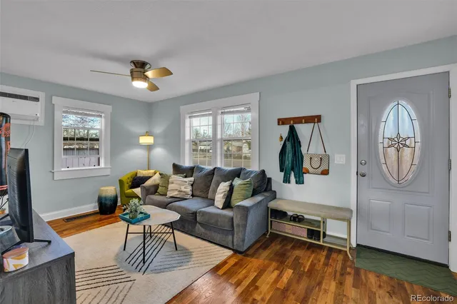 a living room with furniture a rug a window and a flat screen tv