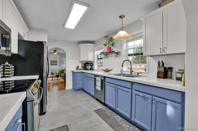 a kitchen with granite countertop stainless steel appliances a sink dishwasher a refrigerator cabinets and a counter top space