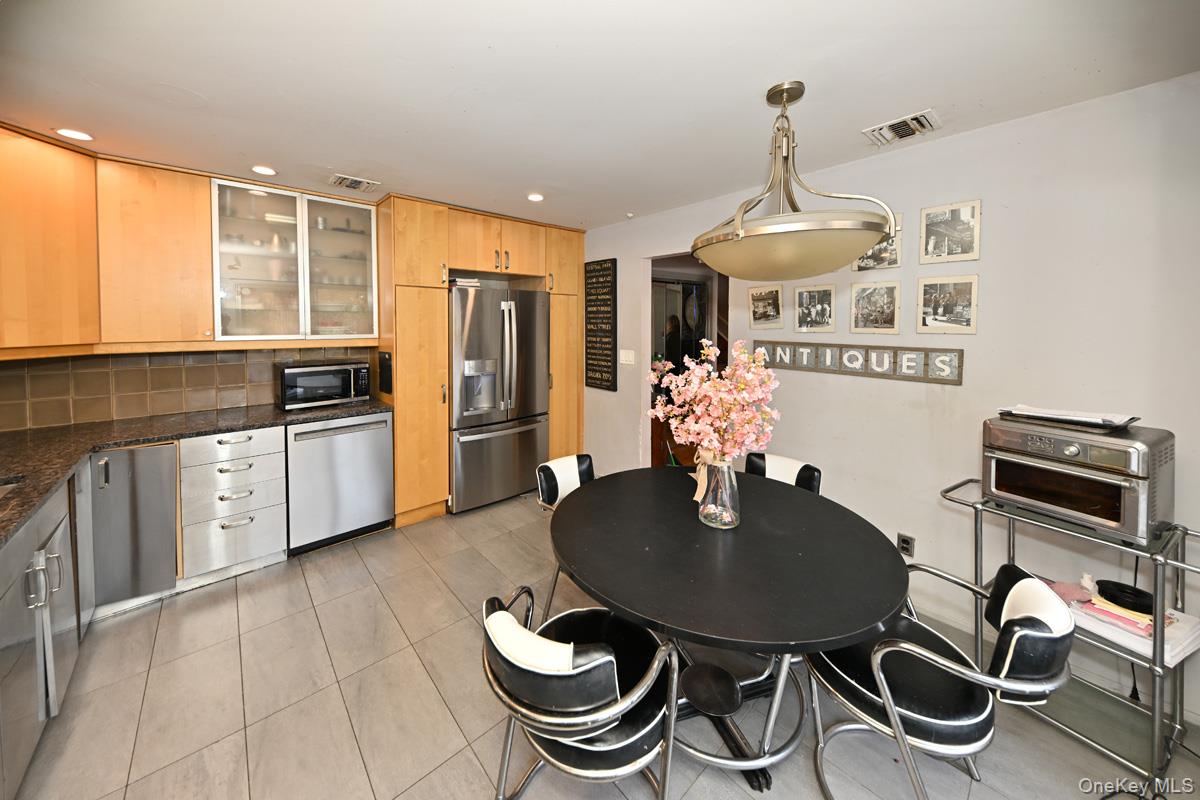11 Lomond Avenue Chestnut Ridge, NY 10977 - Photo 11 of 26 Kitchen featuring appliances with stainless steel finishes, pendant lighting, glass insert cabinets, light tile patterned floors, and tasteful backsplash