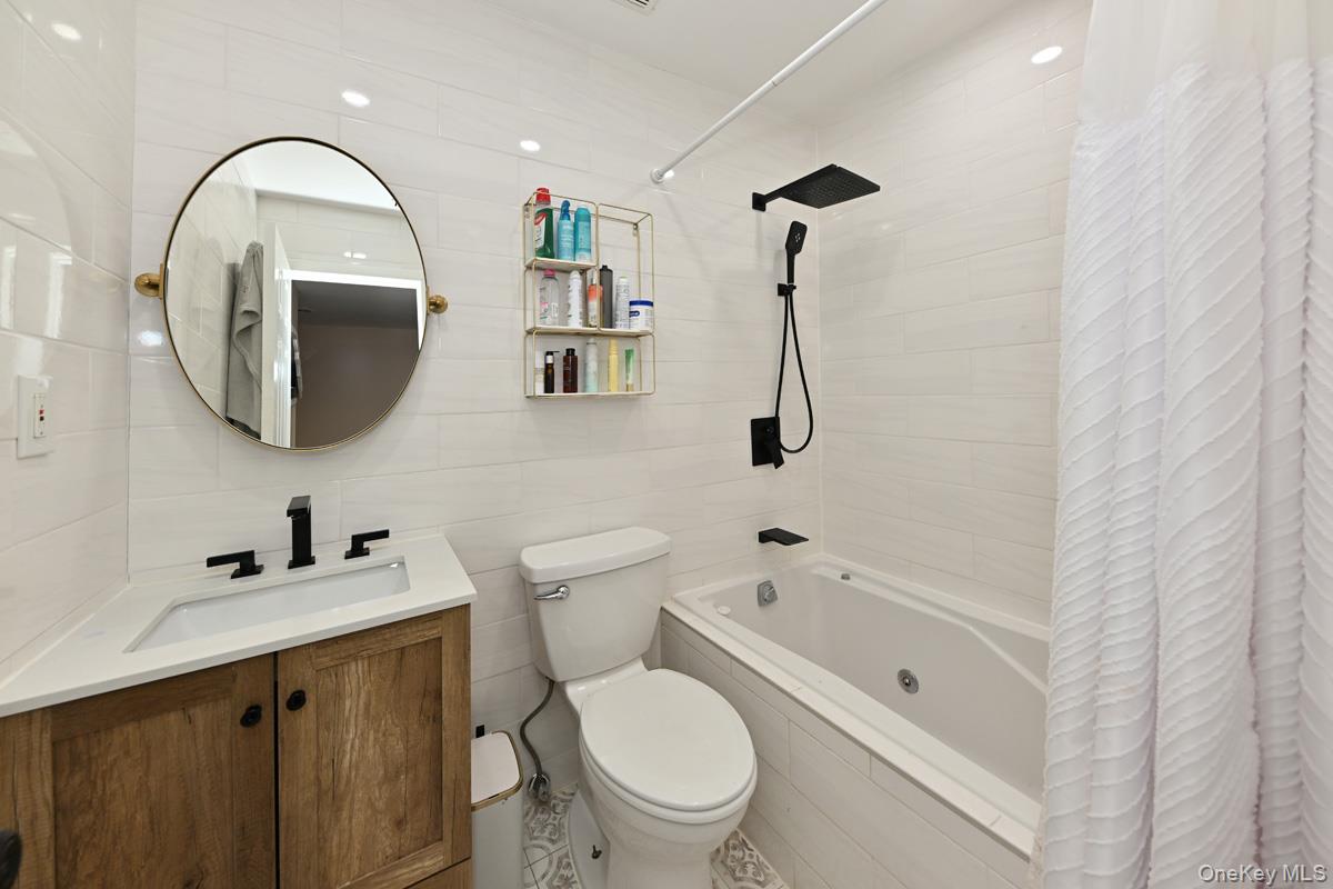 11 Lomond Avenue Chestnut Ridge, NY 10977 - Photo 16 of 26 Bathroom with vanity, tiled shower / bath, and tile walls