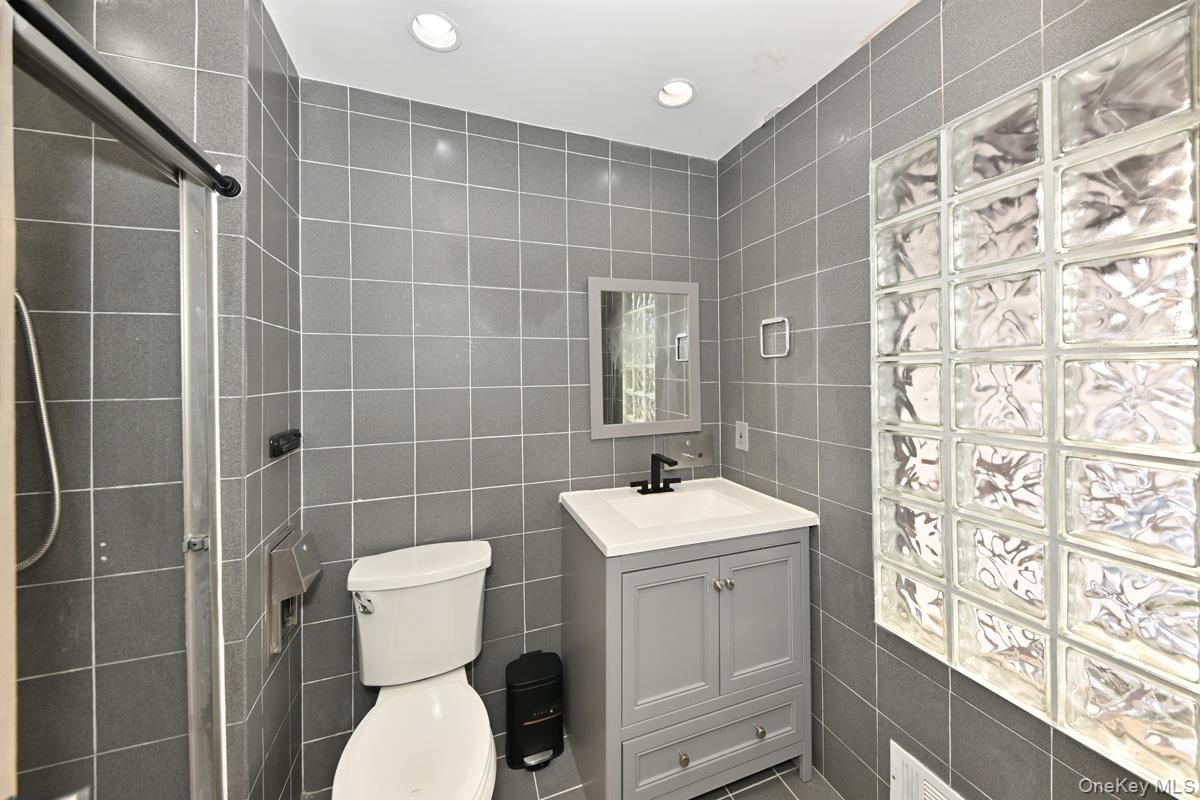 11 Lomond Avenue Chestnut Ridge, NY 10977 - Photo 18 of 26 Bathroom with tile walls, vanity, recessed lighting, and a shower