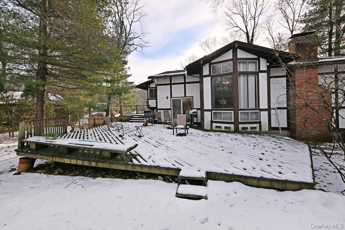 11 Lomond Avenue Chestnut Ridge, NY 10977 - Photo 2 of 26 Snow covered rear of property featuring a deck, a chimney, and stucco siding