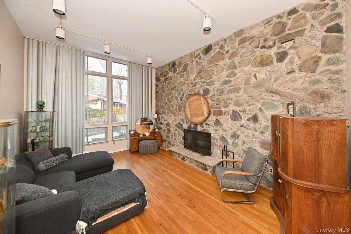 11 Lomond Avenue Chestnut Ridge, NY 10977 - Photo 3 of 26 Living area featuring track lighting, hardwood / wood-style floors, and a stone fireplace