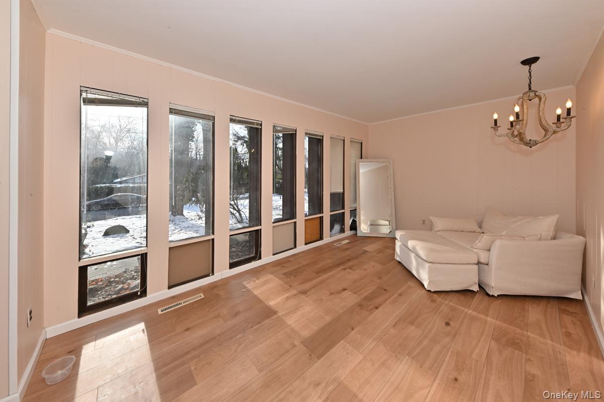 11 Lomond Avenue Chestnut Ridge, NY 10977 - Photo 7 of 26 Living room featuring crown molding, light wood finished floors, and a chandelier