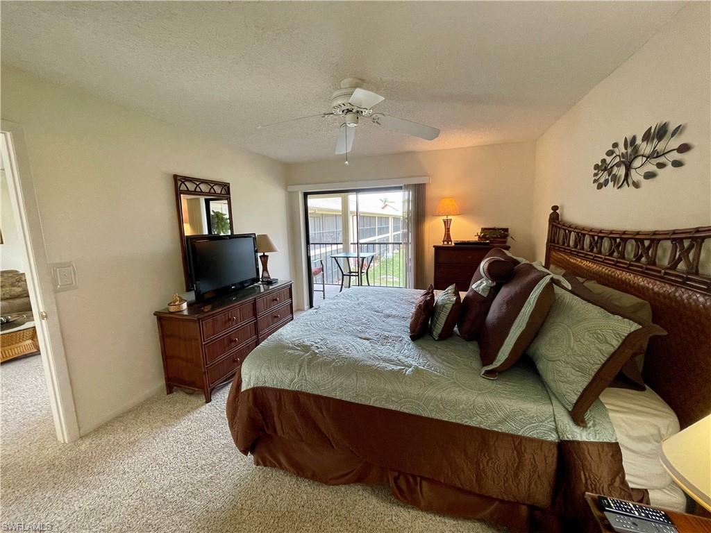 256 Pebble Beach Circle, Unit D201 Naples, FL 34113 - Photo 11 of 19 a bedroom with a bed and a television