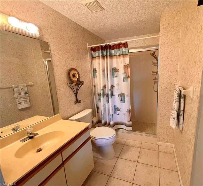 256 Pebble Beach Circle, Unit D201 Naples, FL 34113 - Photo 12 of 19 a bathroom with a sink toilet and shower