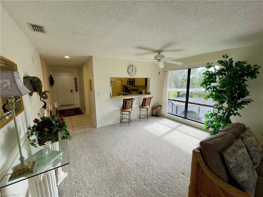 256 Pebble Beach Circle, Unit D201 Naples, FL 34113 - Photo 7 of 19 a living room with furniture and a large window