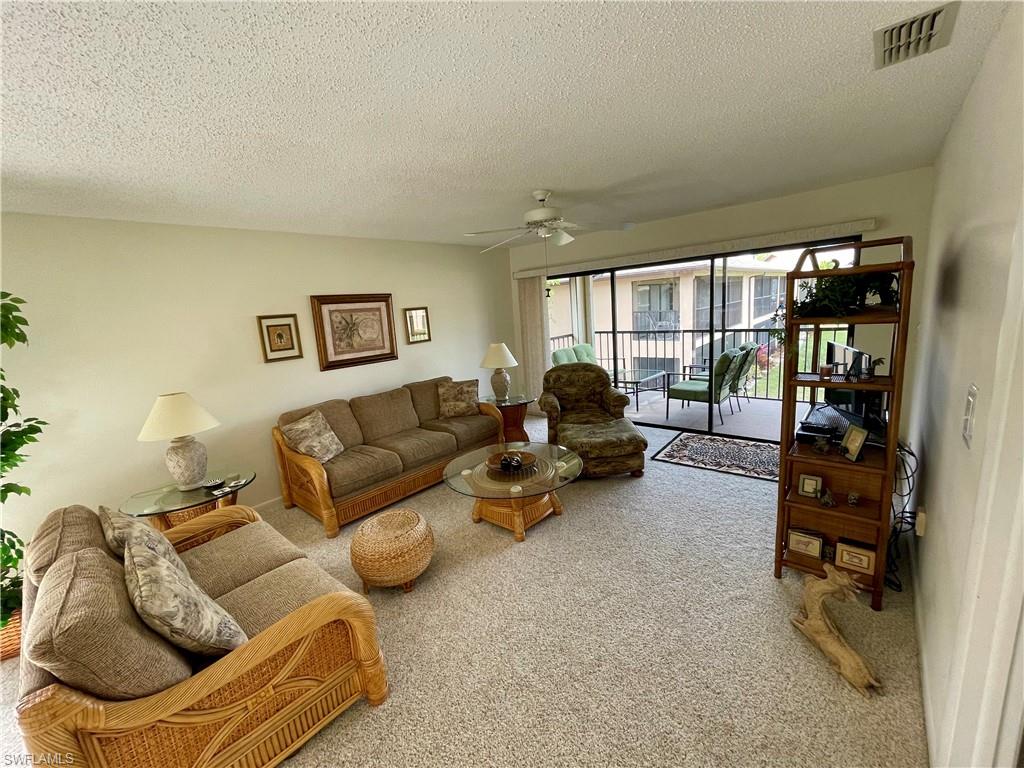 256 Pebble Beach Circle, Unit D201 Naples, FL 34113 - Photo 9 of 19 a living room with furniture and a large window