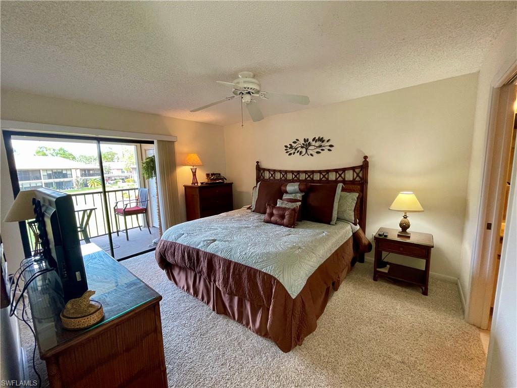 256 Pebble Beach Circle, Unit D201 Naples, FL 34113 - Photo 10 of 19 a bedroom with furniture and large windows