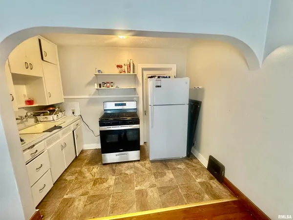 a kitchen with a refrigerator and a stove