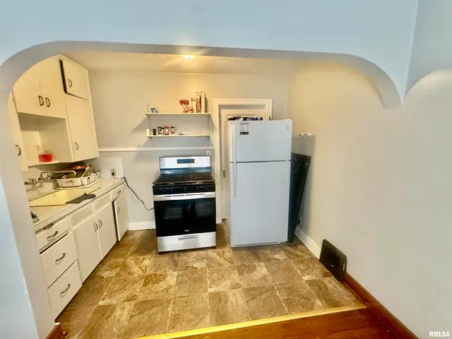 a kitchen with a refrigerator and a stove