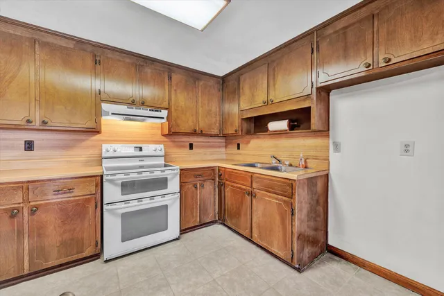an empty room with windows and chandelier fan