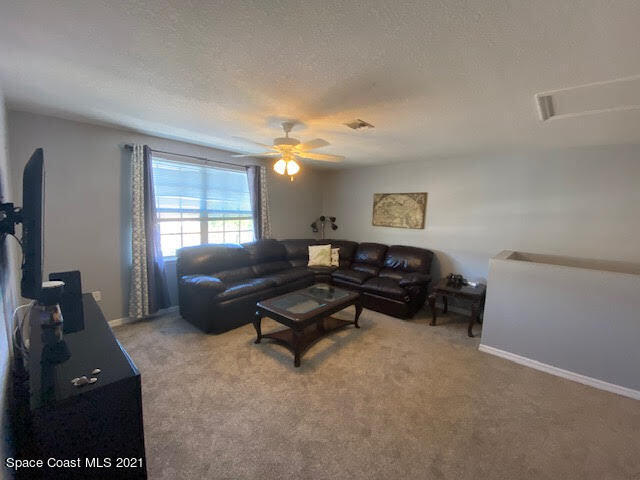 105 Turpial Way, Unit 105 Melbourne, FL 32901 - Photo 14 of 25 a living room with furniture and a flat screen tv