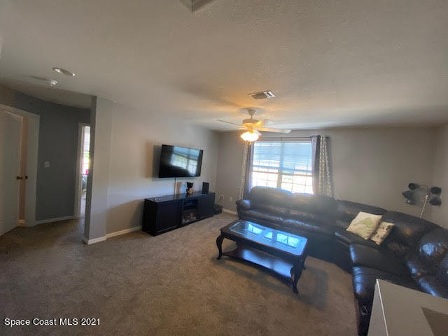 105 Turpial Way, Unit 105 Melbourne, FL 32901 - Photo 15 of 25 a living room with furniture and a flat screen tv