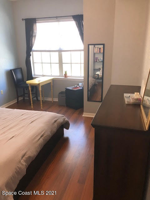 105 Turpial Way, Unit 105 Melbourne, FL 32901 - Photo 17 of 25 a bedroom with a bed and a large window