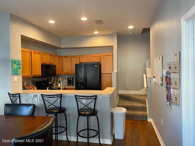 105 Turpial Way, Unit 105 Melbourne, FL 32901 - Photo 5 of 25 a kitchen with stainless steel appliances granite countertop a refrigerator and a dining table