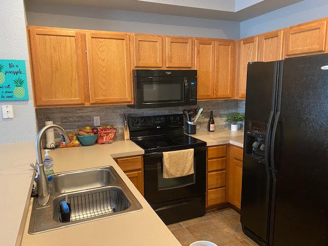 105 Turpial Way, Unit 105 Melbourne, FL 32901 - Photo 6 of 25 a kitchen with a refrigerator stove and a sink