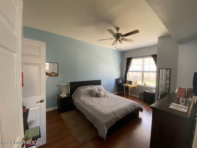 105 Turpial Way, Unit 105 Melbourne, FL 32901 - Photo 10 of 25 a bedroom with a bed and a chandelier