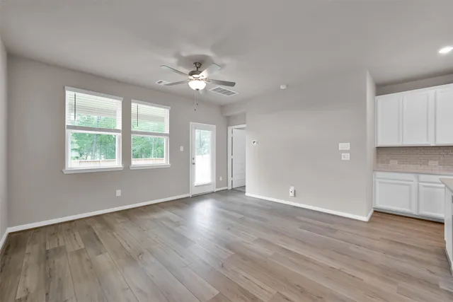 wooden floor in an empty room with a window