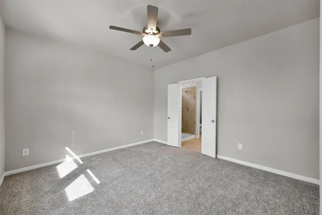 an empty room with a ceiling fan and a window