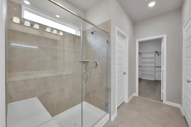 a bathroom with a shower and a glass door