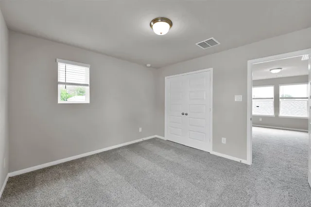 an empty room with windows and closet