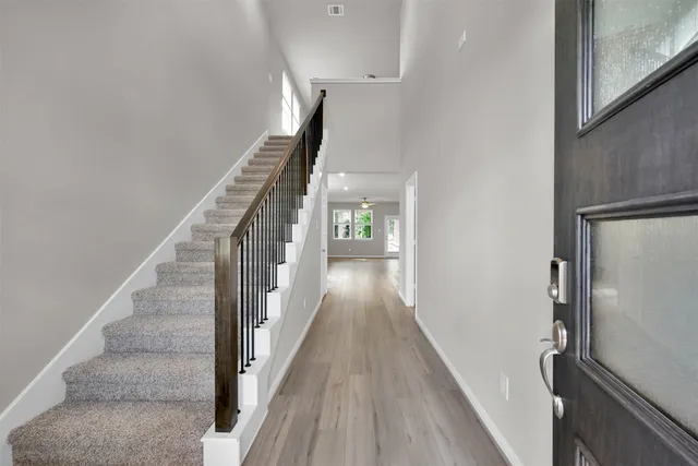 a view of a hallway with wooden floor and staircase
