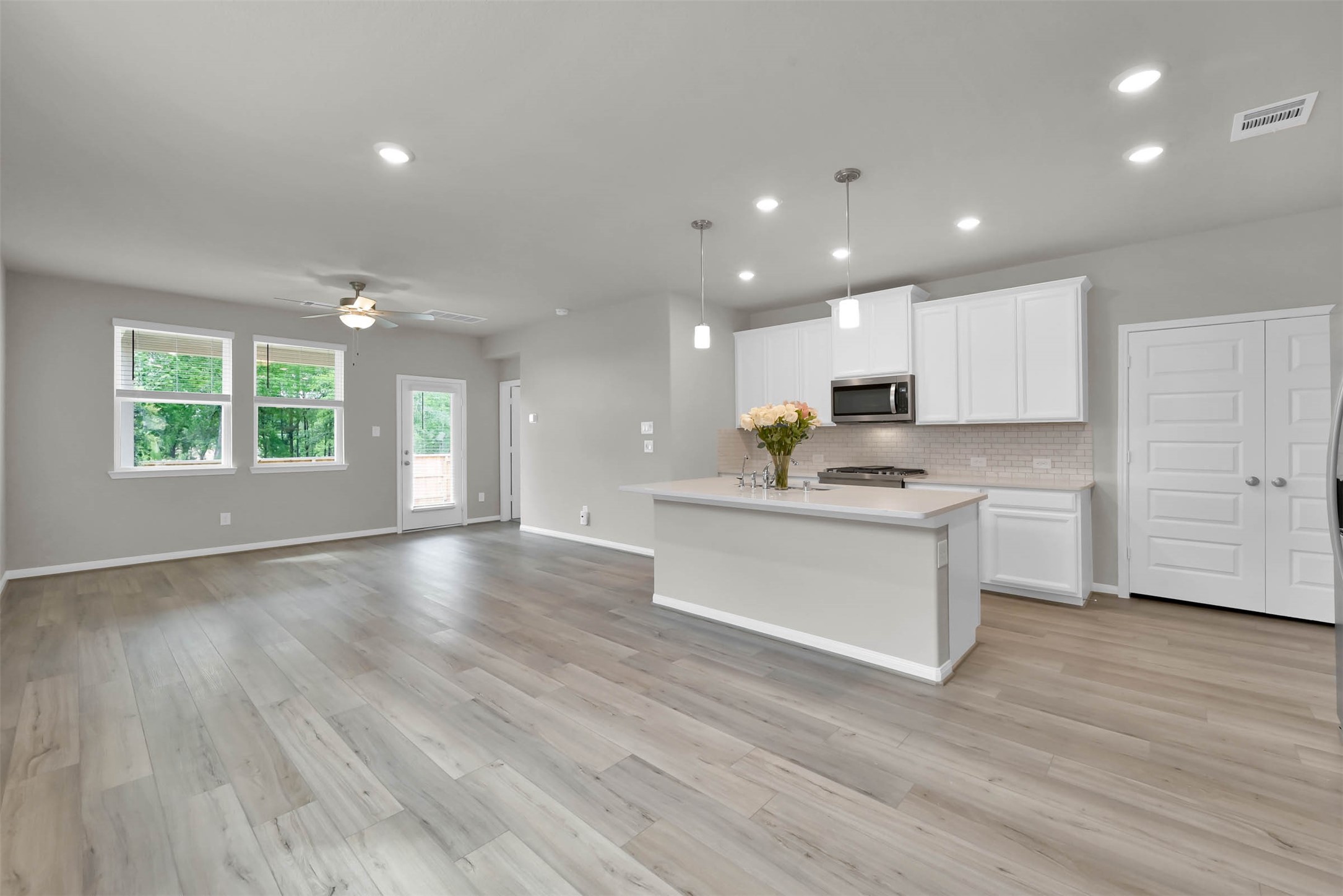 213 Harper Ridge Drive Montgomery, TX 77316 - Photo 5 of 34 a view of kitchen with granite countertop kitchen island wooden floors white cabinets appliances and a window