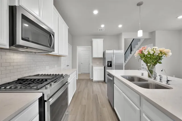 a kitchen with a sink and steel appliances