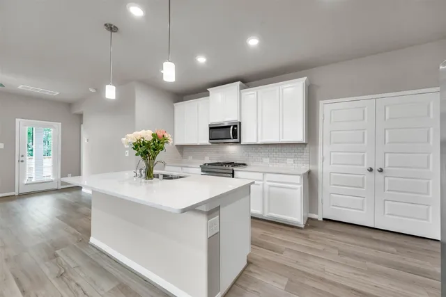 a kitchen with white cabinets and stainless steel appliances