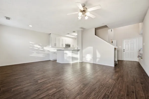 a view of a kitchen with wooden floor and a kitchen space with a sink