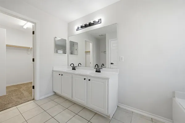 a spacious bathroom with a double vanity sink and mirror