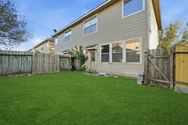 a view of a house with backyard and a tree