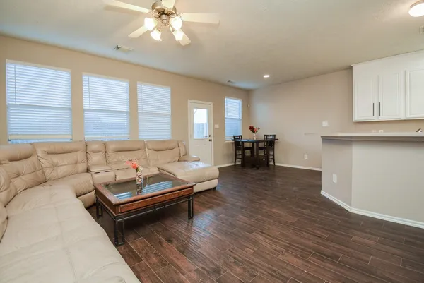 a living room with furniture and a wooden floor