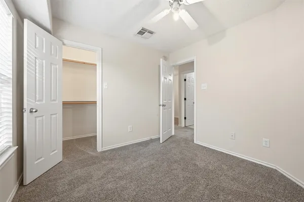 an empty room with windows and closet