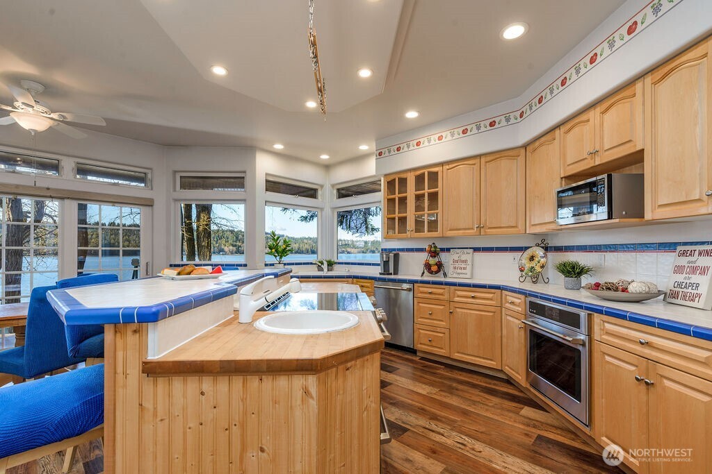 3250 Highway 302 Belfair, WA 98528 - Photo 12 of 40 a kitchen with stainless steel appliances granite countertop a sink a stove and cabinets