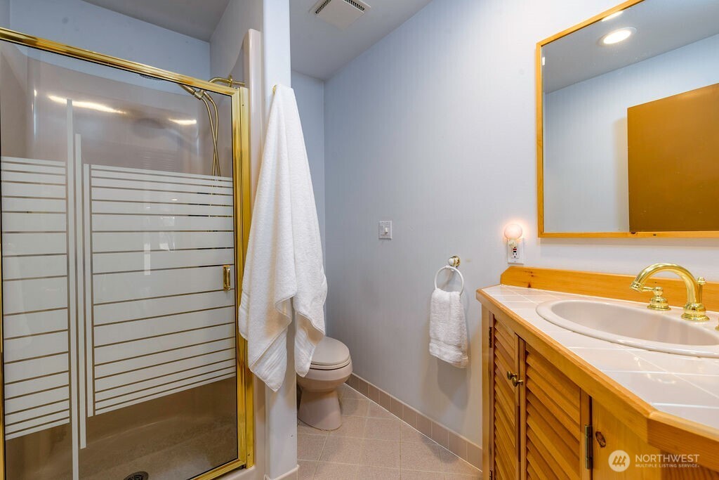 3250 Highway 302 Belfair, WA 98528 - Photo 33 of 40 a bathroom with a sink a toilet and shower