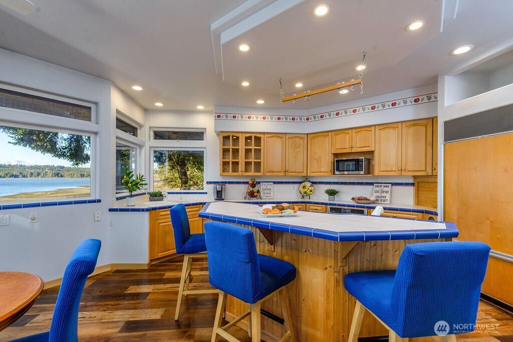 3250 Highway 302 Belfair, WA 98528 - Photo 10 of 40 a dining table and chairs in a kitchen with stainless steel appliances