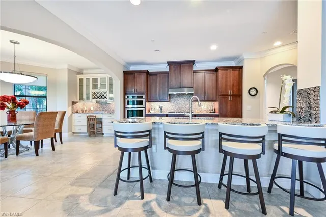 a kitchen with a dining table chairs and view living room