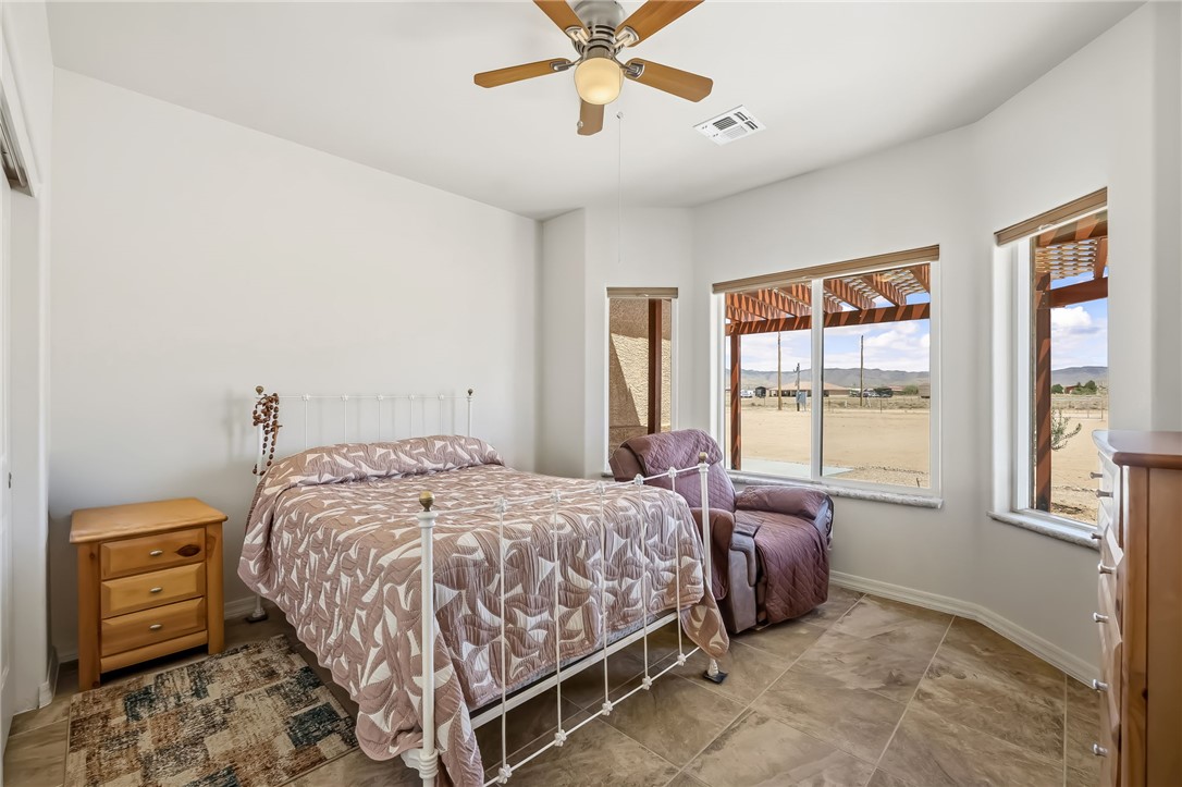 10809 North Jemez Road Kingman, AZ 86401 - Photo 24 of 51 Room featuring multiple windows, a ceiling fan with integrated lighting, and tile flooring