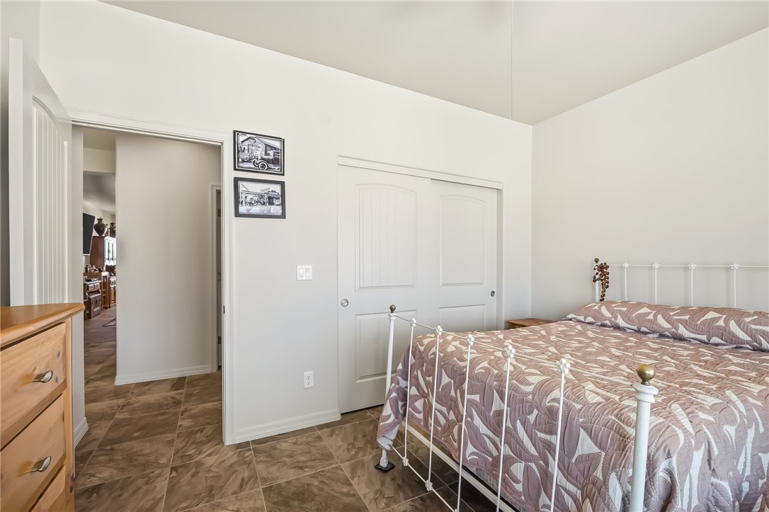 10809 North Jemez Road Kingman, AZ 86401 - Photo 26 of 51 Bedroom featuring neutral wall paint, tile flooring, and a closet with sliding doors