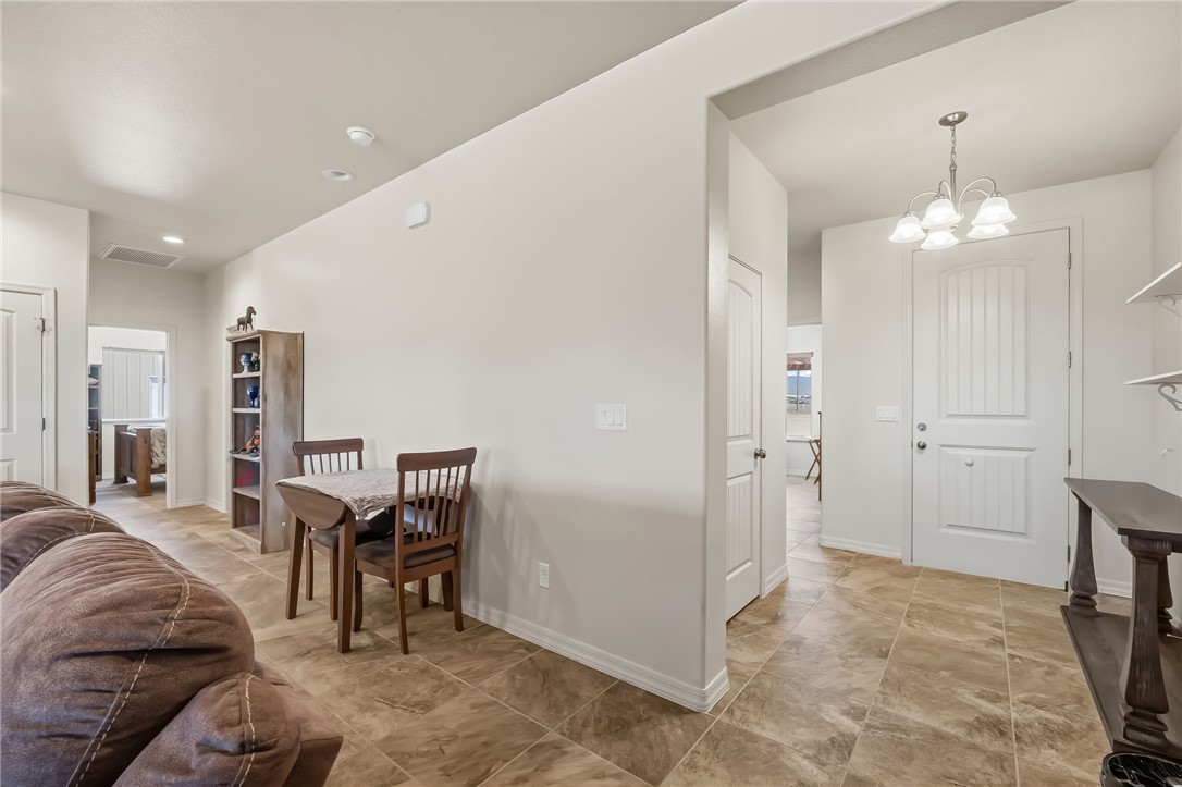 10809 North Jemez Road Kingman, AZ 86401 - Photo 30 of 51 Foyer featuring a white paneled door with brushed nickel hardware, a four-light chandelier, and large-format tile flooring