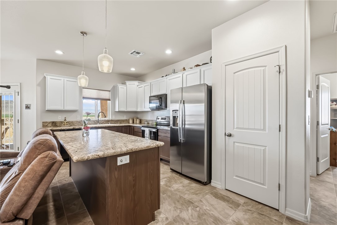 10809 North Jemez Road Kingman, AZ 86401 - Photo 34 of 51 Kitchen featuring a central island with stone countertop, white upper cabinetry, and stainless steel appliances
