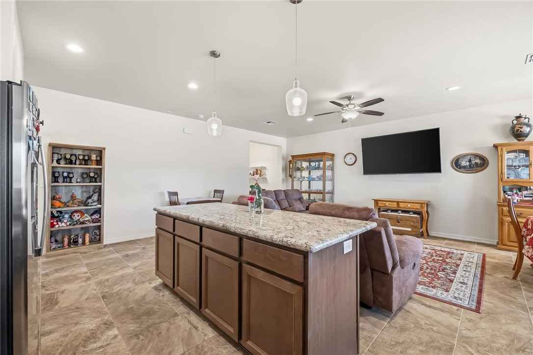 10809 North Jemez Road Kingman, AZ 86401 - Photo 36 of 51 Kitchen island featuring a granite countertop and wood-finish cabinetry