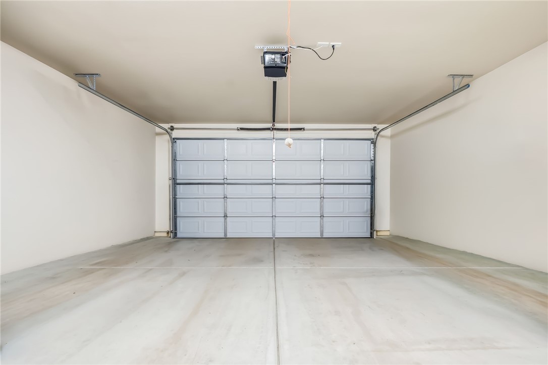 10809 North Jemez Road Kingman, AZ 86401 - Photo 39 of 51 Attached garage with a panel-style door, concrete flooring, and a ceiling-mounted automatic opener
