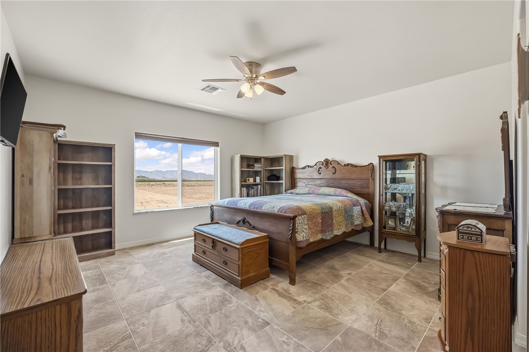10809 North Jemez Road Kingman, AZ 86401 - Photo 43 of 51 Spacious bedroom featuring light-toned walls, tile flooring, and a window providing expansive exterior scenery
